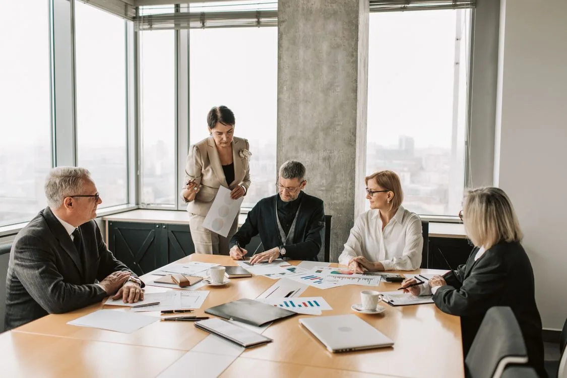 Professionals reviewing a business plan around a meeting table